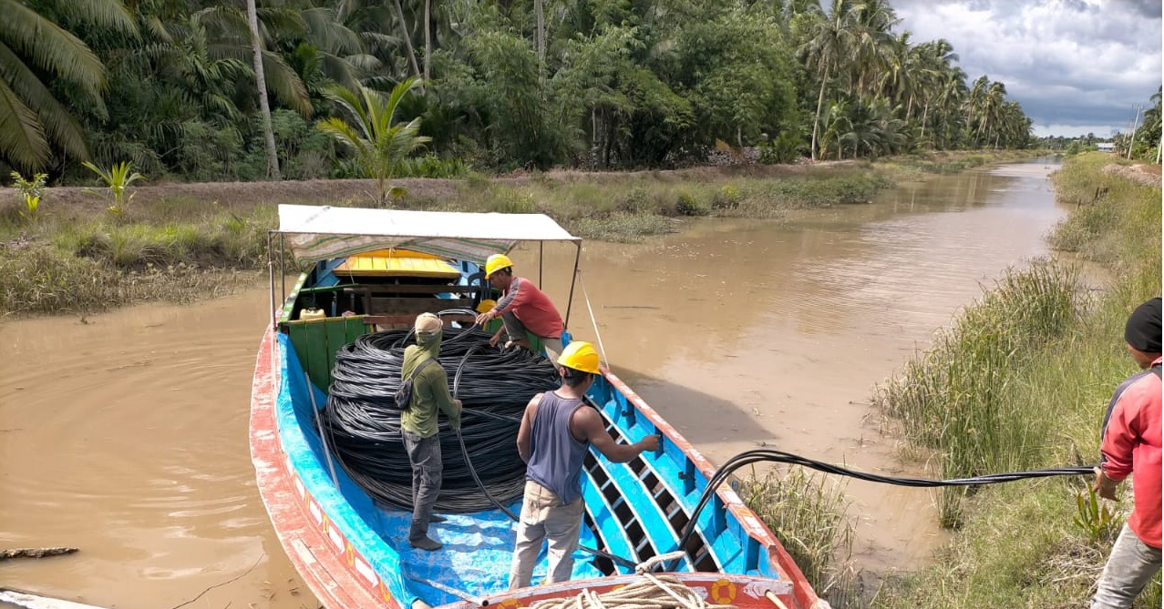 Petugas PLN saat melakukann pemasangan kabel di Desa Perajen Jaya, Kabupaten Banyuasin