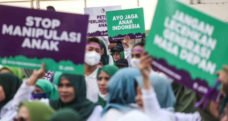 Sejumlah relawan membawa poster saat penandatanganan petisi perlindungan anak di Sarinah, Jakarta, Minggu (8/1/2023)