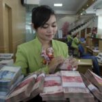 foto: salah satu kasir bank saat menghitung manual uang rupiah