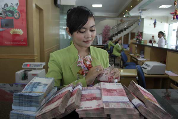 foto: salah satu kasir bank saat menghitung manual uang rupiah